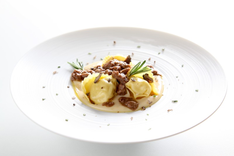 Goose egg rosemary tortelli filled with lake carp on a caciotta cheese fondue with deer ragout and black truffle